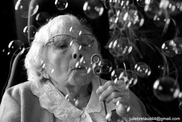 Femme agées soufflant des bulles de savon