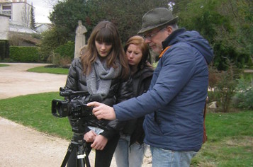 Alain Benesty et 2 jeunes regardant l'écran d'une camera