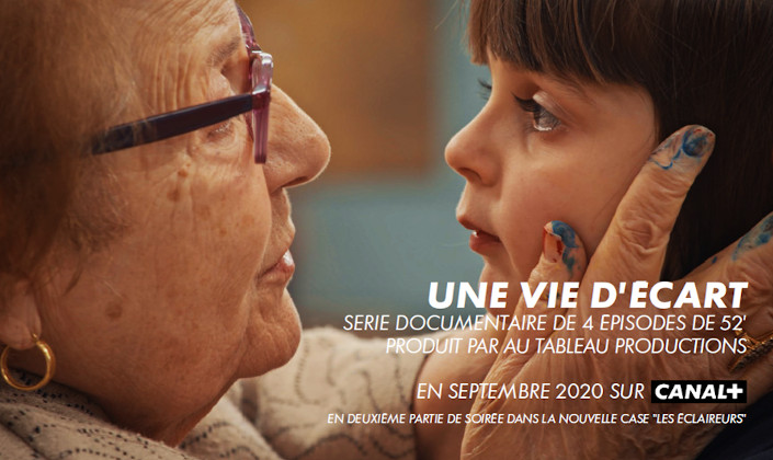 Une dame âgée prend le visage d'une petite fille dans ses mains. Toutes deux se regardent dans les yeux.
