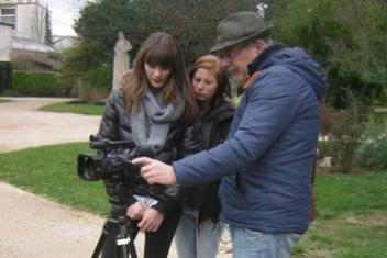 Alain Benesty et 2 jeunes regardant l'écran d'une camera