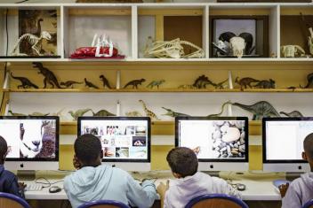 Quatre enfants de dos devant des ordinateurs