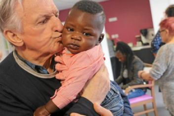 Homme âgé embrassant un enfant en bas âge