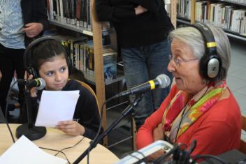 une petite fille et une séniors faisant de la radio