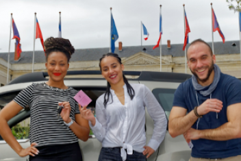 Trois personnes se tenant devant une voiture