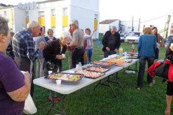 Habitants autour d'une table, partageant l'aperitif.