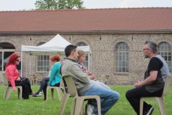 Personnes en groupe assis sur des chaises sur une pelouse
