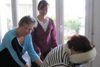 Deux personnes aidants une personne en situation de handicap