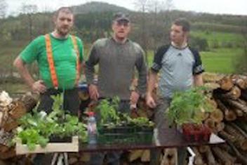 Trois personnes devant une table avec des plantes