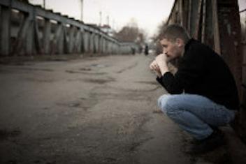 Une personne accroupie sur le bord de la route