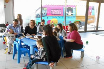 Enfants et parents partageant un gouter autour d'une table pour enfants