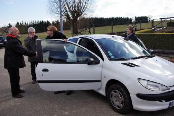 Quatre personne autour d'une voiture