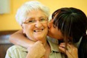 Une jeune qui fait un bisous à une personne âgée