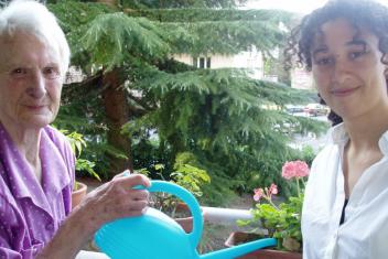 Une jeune et une sénior qui arrosent des plantes