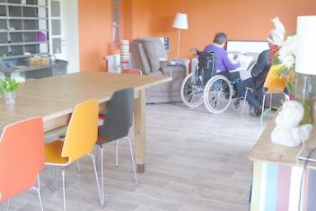 Une personne en fauteuil roulant avec une autre personne dans une salle 