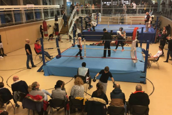 Vue d'un hall de sport avec un plateau de boxe et des spectateurs