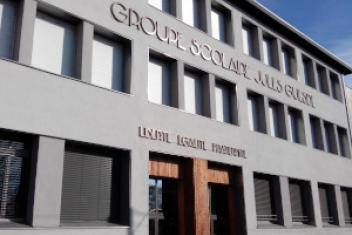 Façade avant d'un groupe scolaire, "groupe scolaire Jules ..." et "Liberté Egalité Fraternité" écris sur cette façade. 
