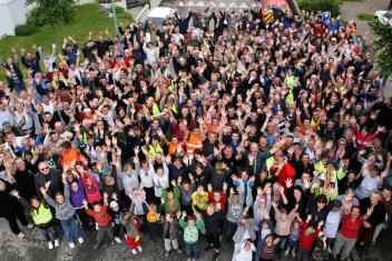 Groupe de plusieurs centaines de personne levant les bras face au photographe
